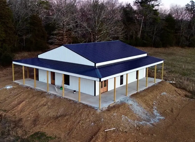 Aerial view of barndominium with wraparound porch