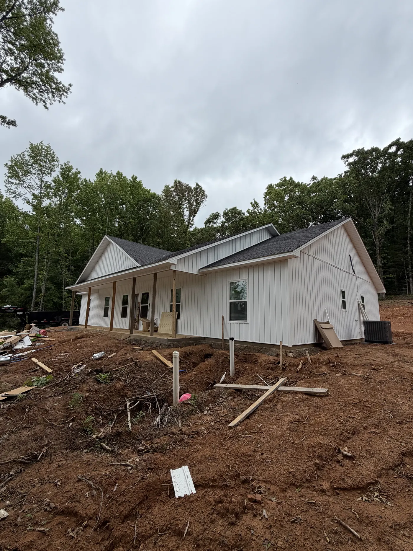 White farmhouse with covered porch during final grading