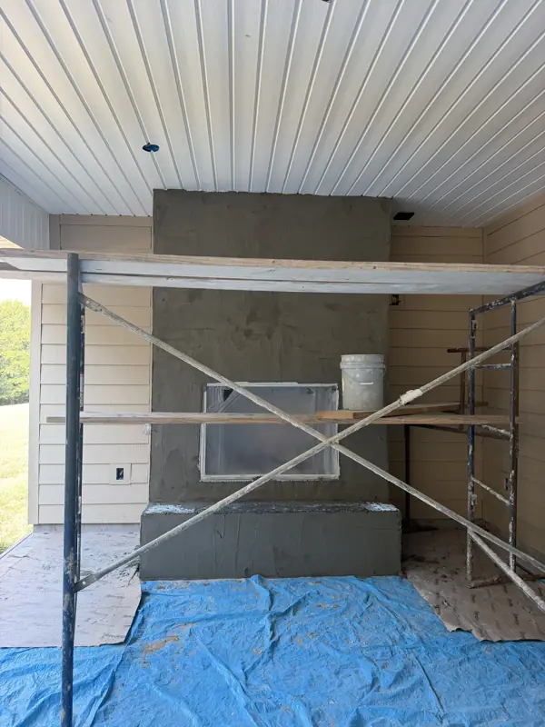Stone veneer being applied to an exterior fireplace