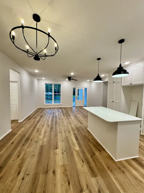 Open great room with chandelier and wood floors