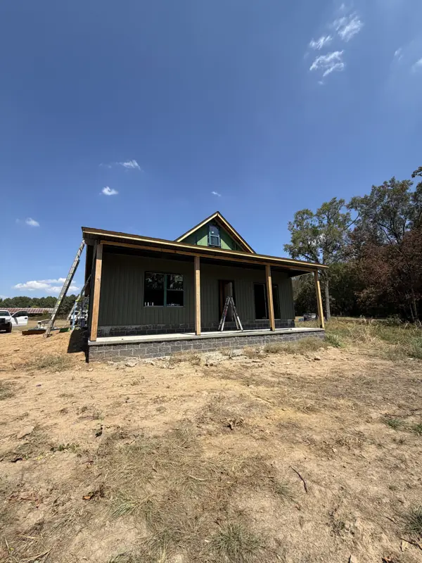 Dark green cottage with covered porch