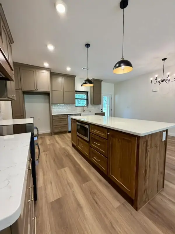 Taupe kitchen with wood island and white countertops